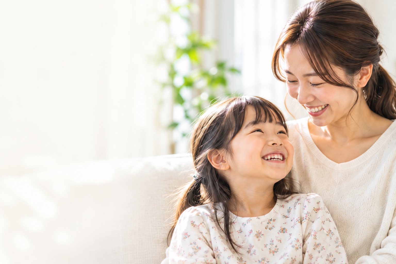自然な笑顔で見つめ合う親子のイメージ